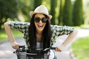 Woman happy on bike not imprisoned by a mini skirt because mini skirts are not good for women