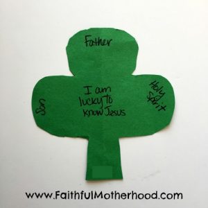 Simple cut out shamrock with words: Father, Son, and Holy Spirit. In the center is written I am lucky to know Jesus. Faith lessons from St. Patrick's Day