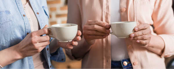 two women holding coffee cups - homeschooling with depression