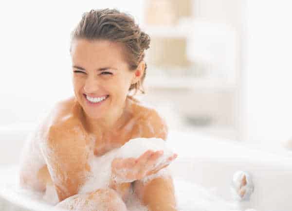 self-care for homeschool moms can look like a bubble bath.  This mom has a look of joy on her face and is like a little kid with a handful of bubbles. 