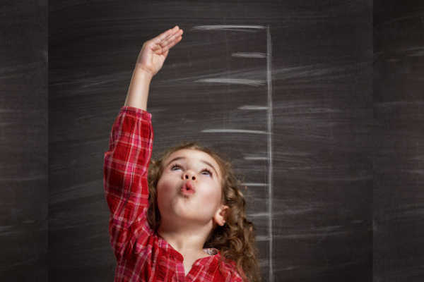 Girl in red plaid measuring up