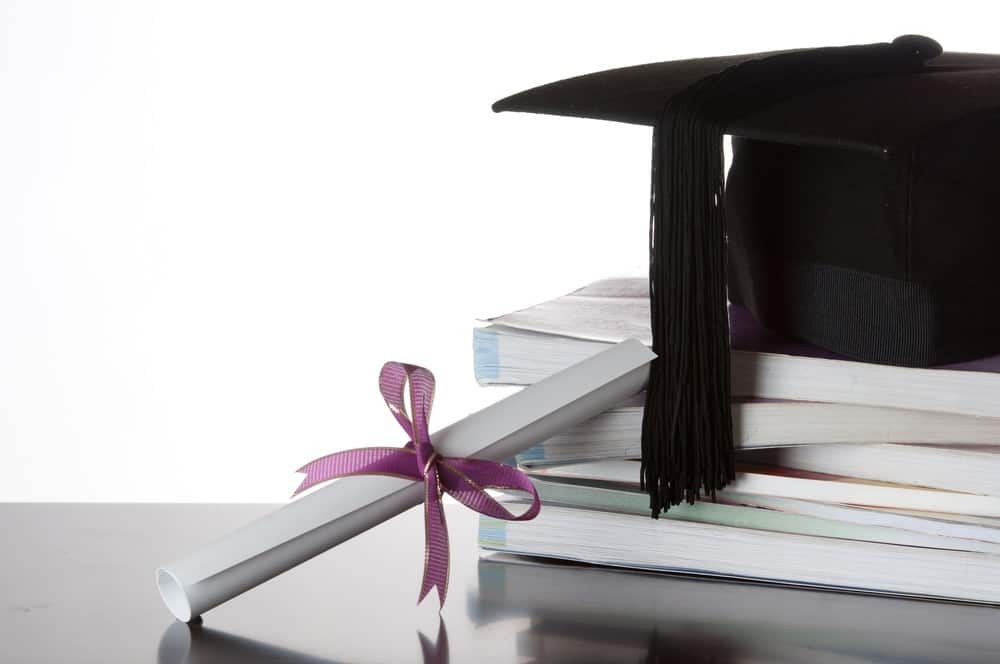 graduation gap on top of a stack of books, faith in college