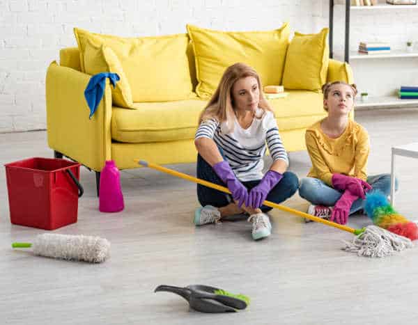 Mom and daughter frustrated and tired from cleaning all the clutter at their house.  A good reason to teach kids to declutter and have less housework. 