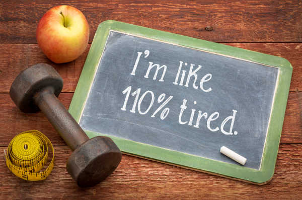 Wooden table with chalkboard.  An exhausted, sleep deprived mom wrote "I'm like 110% tired." Plus a measuring tape, apply, and hand weight. 