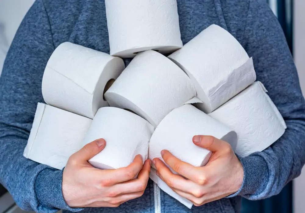 Man holding his stash of toilet paper, hopefully he will teach kids good stewardship.
