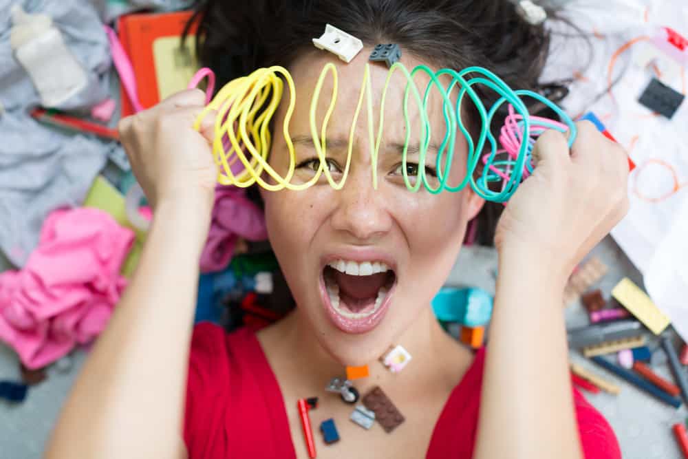 young woman, who is not practicing good stewardship, is overwhelmed by all the stuff in her room. 