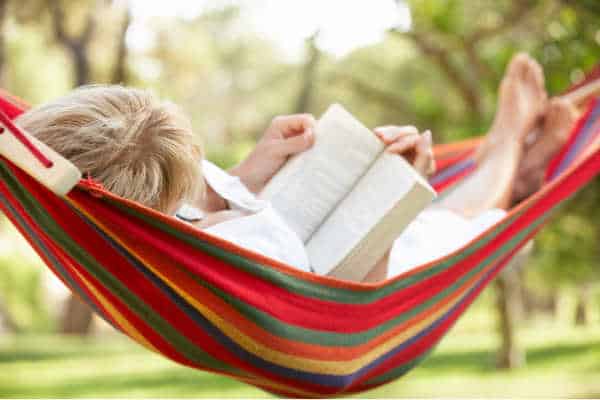 Tired homeschool mom taking a break in a hammock, reading a book so she doesn't quit homeschooling. 