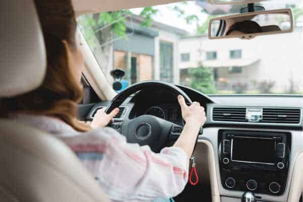 View from backseat of a woman driving down the street - she is not looking at her phone instead so she can pray without ceasing