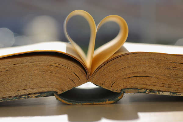 Older worn Bible open with middle pages shaped into a heart outline - inspiring prayer before Bible study 