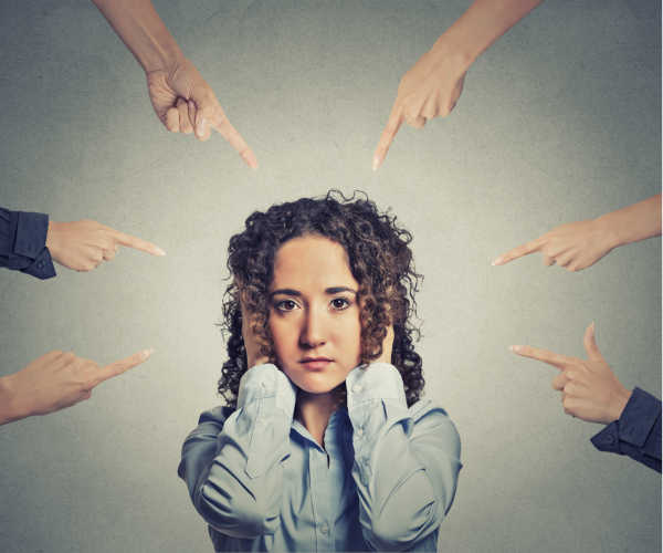 What it looks like when someone questions your call - six different hands with fingers pointed all at one woman.  She looks sad and overwhelmed with her hands over her ears and looking directly at you. 