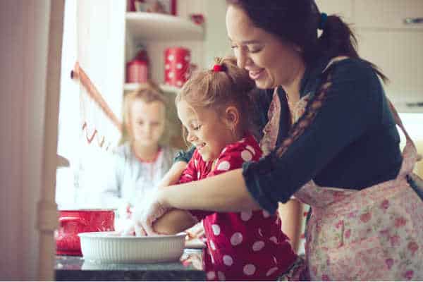 Mom and children baking at Christmas time, it counts as homeschooling during the holidays. 