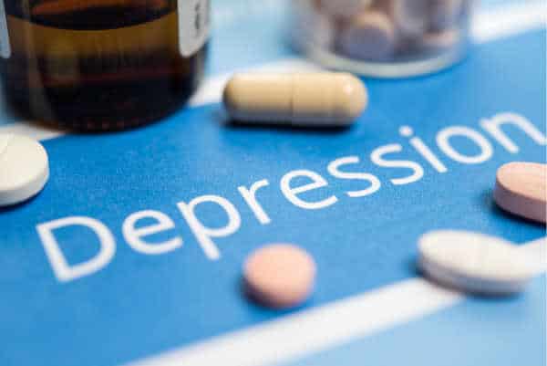 Pills and a blue background with the word depression written on it