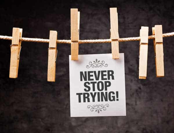 Never Stop Trying motivational message printed on note paper and hanged on clothesline with pins  - when homeschooling with depression never stop trying to find help