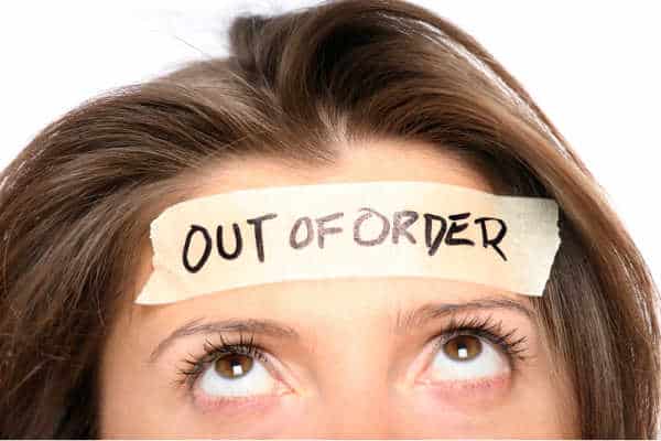 Woman with brunette hair and brown eyes.  Picture starts just above her nose.  She is looking up at the masking tape across her forehead that says out of order.  She is illustrating the overwhelmed feeling behind the need for self-care for homeschool moms.