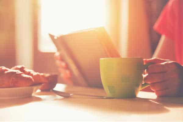 fresh breakfast with hot coffee and reading book in morning sunlight - she has learned what are devotions and is enjoying her morning time with God. 