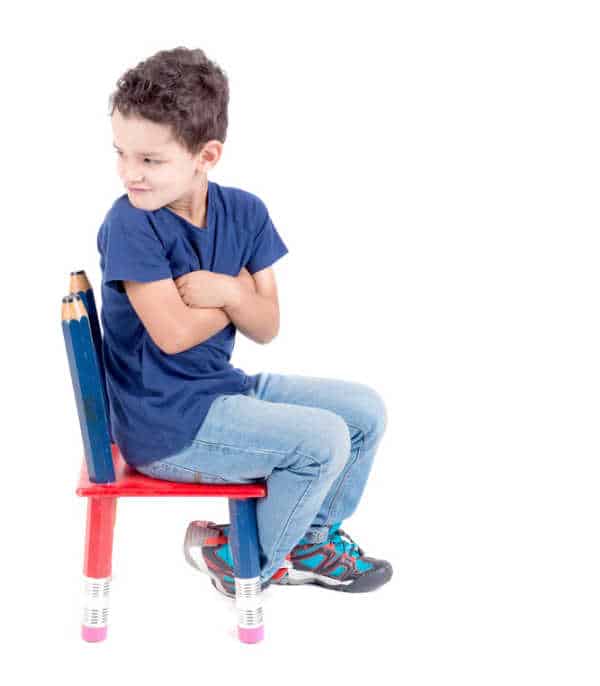 It is hard to parent a bossy child like this one who is pouting and has his face turned away.  He has his arms crossed and is sitting in time out. 