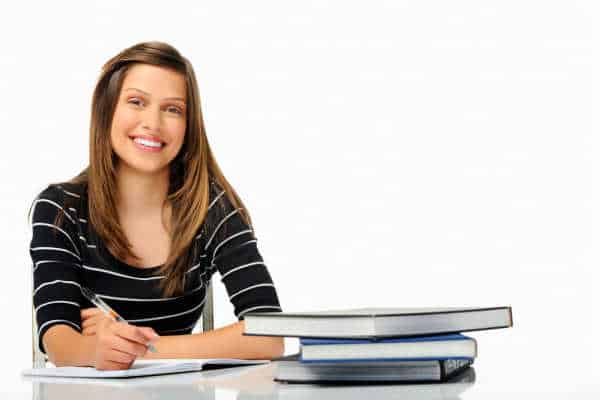 Happy young woman in a black and white stripped shirt studying and learning how to - prepare your homeschoooler to be an entreprenuer