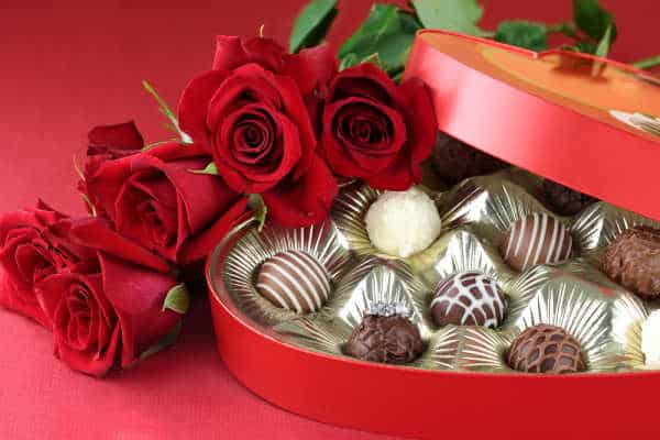 Heart-shaped box of chocolate truffles with red roses.  Traditional gifts for St. Valentine's Day. 